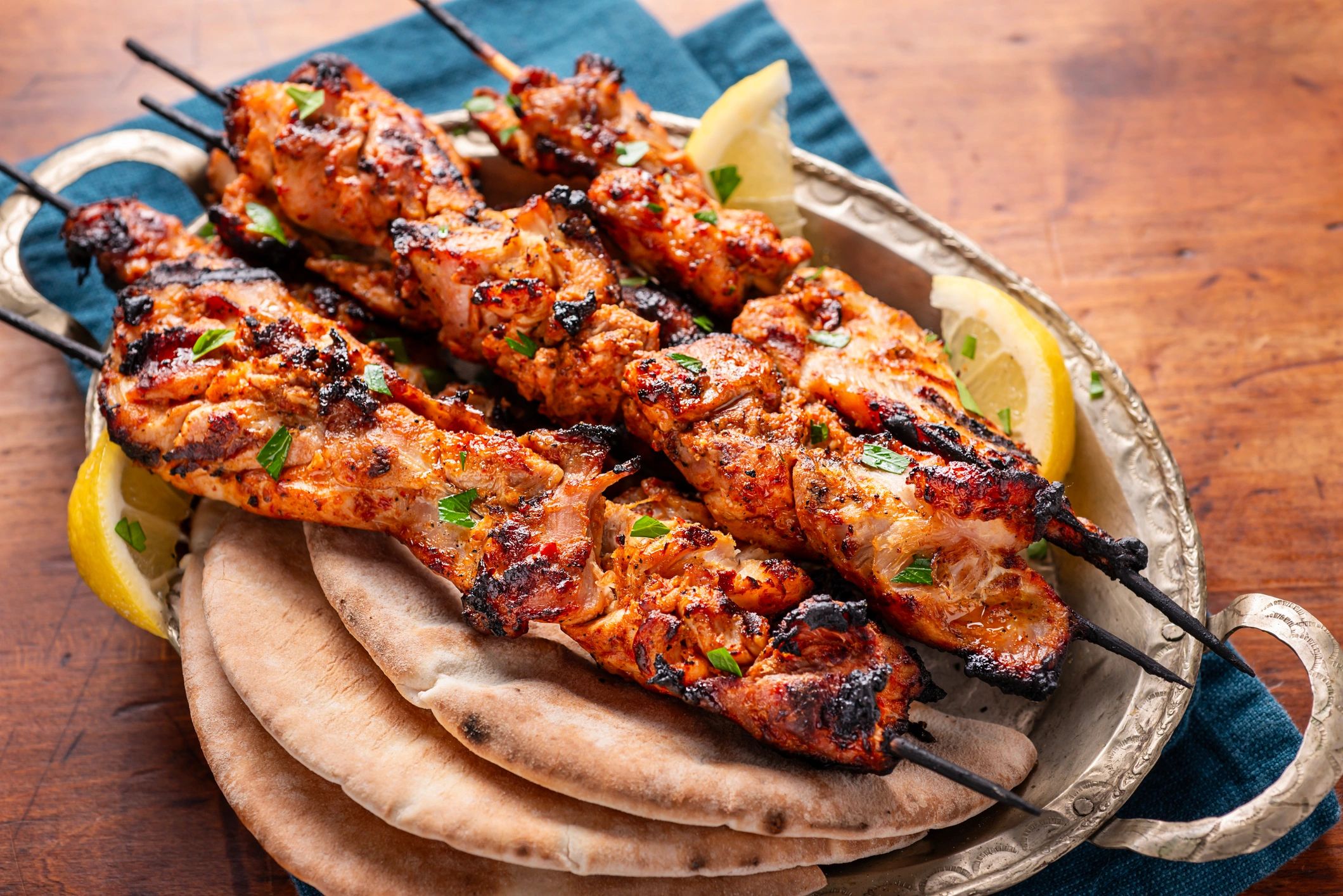 Grilled chicken skewers with pita and lemon